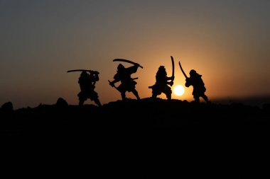 Düelloda dört samurais silüeti. İki samurais ve günbatımı gökyüzü ile hayal et. Seçici odak
