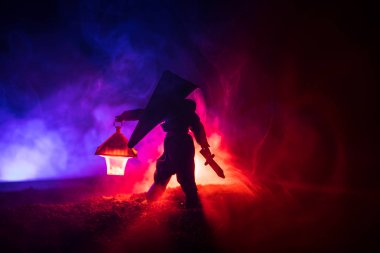 Yağmurluk ile onun el kavramı içinde parlayan fener karanlık ormanın gelen adam. Lamba korku katille silüeti. Silent Hill canavar bezemeleri
