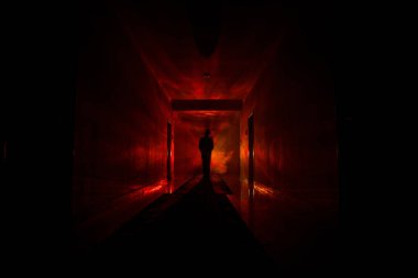 Ürpertici siluet koyu terk edilmiş binada. Manyak genel kavram ya da kabine kapılar ile karanlık koridor ve ışıkları ile farklı pozlar duran korkunç korku kişi silueti ile ilgili korku.