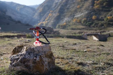 Nargile, geleneksel Arapça harcamak, doğrudan günbatımı güneş ışığı, açık fotoğraf. Dağ arka plan. Açık. Boş alan.