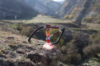 Nargile, geleneksel Arapça harcamak, doğrudan günbatımı güneş ışığı, açık fotoğraf. Dağ arka plan. Açık. Boş alan.