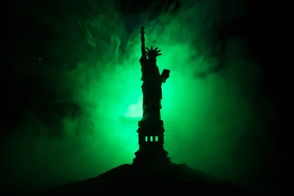 Silhouette statue of liberty on dark toned foggy background. Statue of Liberty on the background of colorful foggy sky. Decorated image.
