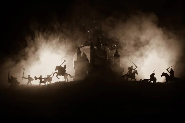 騎兵や歩兵との中世の戦闘シーン 中世の城と暗いトーン霧の背景に戦士の間で戦う 別のオブジェクトとしての人物のシルエット 選択的焦点 — ストック写真
