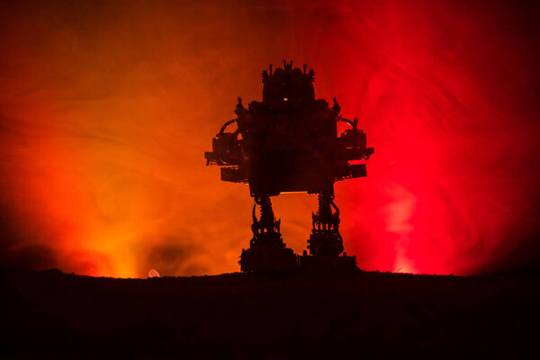 Silhouette of Giant robot. Futuristic tank in action with foggy fire sky background. Combat vehicle.