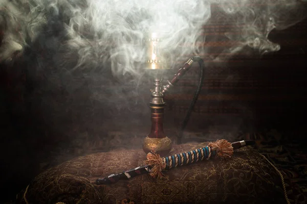 水烟碗上的水烟热煤制作阿拉伯内部的蒸汽云 地毯上的东方装饰品 时尚的东方水烟与背光 水烟广告 选择性聚焦 — 图库照片