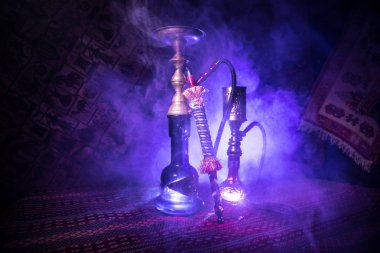 Nargile kömürü nargile kupa Arap iç de buhar bulutları yapma. Şark süsleme halı üzerinde. Şık oryantal shisha içinde karanlık arka ışık ile. Shisha reklam için. Seçici odak