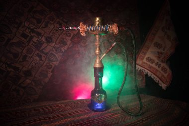 Nargile kömürü nargile kupa Arap iç de buhar bulutları yapma. Şark süsleme halı üzerinde. Şık oryantal shisha içinde karanlık arka ışık ile. Shisha reklam için. Seçici odak