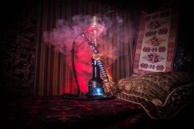 Nargile kömürü nargile kupa Arap iç de buhar bulutları yapma. Şark süsleme halı üzerinde. Şık oryantal shisha içinde karanlık arka ışık ile. Shisha reklam için. Seçici odak