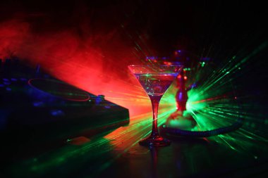 Martini gece kulübünde dj denetleyicisinde içinde zeytin ile bardak. Club içki gece kulübünde şık oryantal shisha ile müzik partide DJ konsolu