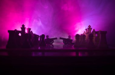 Satranç tahtası üzerinde iki top ile ortaçağ savaş sahnesi. Satranç oyununu kavramı iş fikirleri ve rekabet ve strateji fikirler duman ve sis karanlık bir arka plan üzerinde satranç figürleri.