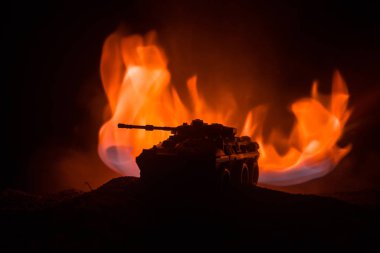 Savaş kavramı. Zırhlı Tank siluet aşağıda sisli yangın gökyüzü gece. Saldırı sahne. Oyuncak dekorasyon. Seçici odak