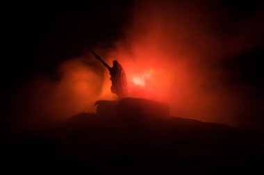 Savaş kavramı. Zırhlı Tank siluet aşağıda sisli yangın gökyüzü gece. Saldırı sahne. Oyuncak dekorasyon. Seçici odak