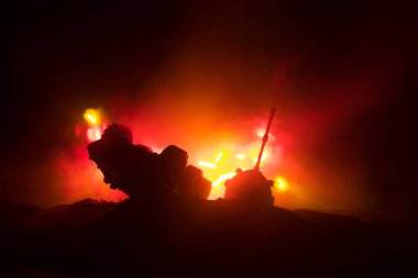 Savaş kavramı. Zırhlı Tank siluet aşağıda sisli yangın gökyüzü gece. Saldırı sahne. Oyuncak dekorasyon. Seçici odak