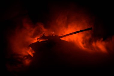 Savaş kavramı. Zırhlı Tank siluet aşağıda sisli yangın gökyüzü gece. Saldırı sahne. Oyuncak dekorasyon. Seçici odak