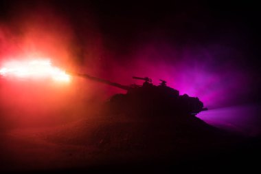 Savaş kavramı. Zırhlı Tank siluet aşağıda sisli yangın gökyüzü gece. Saldırı sahne. Oyuncak dekorasyon. Seçici odak
