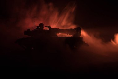 Savaş kavramı. Zırhlı Tank siluet aşağıda sisli yangın gökyüzü gece. Saldırı sahne. Oyuncak dekorasyon. Seçici odak