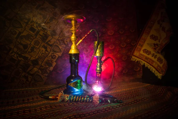 水烟碗上的水烟热煤制作阿拉伯内部的蒸汽云 地毯上的东方装饰品 时尚的东方水烟在黑暗中与背光 水烟广告 选择性聚焦 — 图库照片