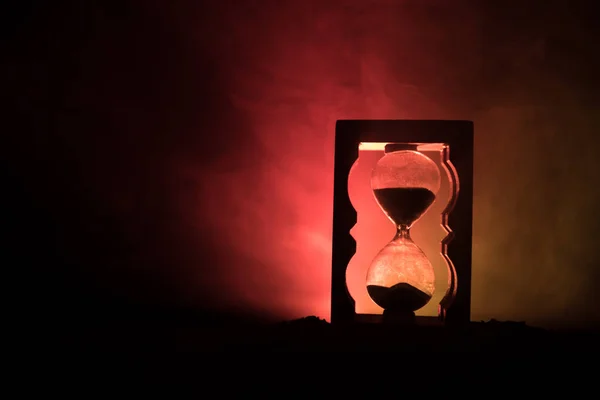 時間の概念 砂時計時計とホット黄色オレンジ赤青色冷たいバックの照明で コピー スペースと暗い背景に煙のシルエット 選択と集中 — ストック写真