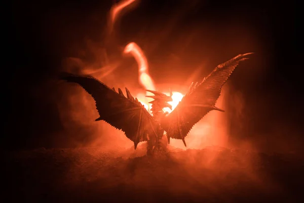 火呼吸龙的剪影与大翼在黑暗的燃烧的火背景 选择性聚焦 — 图库照片