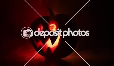 Cadılar Bayramı balkabağı gözlü gece parti için gülümseme ve scrary. İçinde siyah arka plan parlayan gözlerle korkunç Cadılar Bayramı Balkabağı görünümünü kapatın. Seçici odak