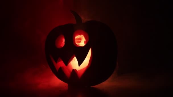 Halloween citrouille sourire et scrary yeux pour la soirée. Vue rapprochée de la citrouille effrayant Halloween avec les yeux brillants à l'intérieur à fond noir. Concentration sélective 