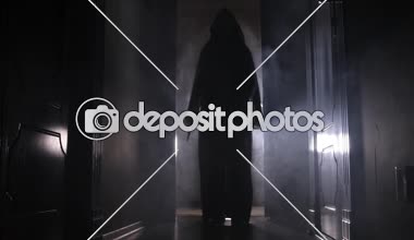 Ürpertici siluet koyu terk edilmiş binada. Korku Cadılar Bayramı kavramı. Karanlık koridor ortasında duran korku kişi silueti ile. Tonda ışık ve sis arka plan üzerinde.