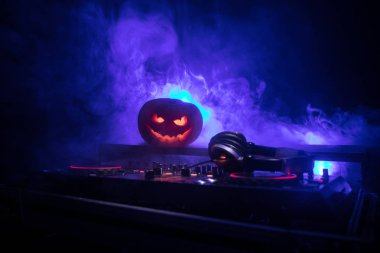 Cadılar Bayramı Balkabağı kopya alanı ile koyu arka plan üzerinde kulaklık ile bir dj tablo. Mutlu Cadılar Bayramı festival süsleri ve müzik konsepti. Boş alanı. Seçici odak