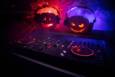 Cadılar Bayramı Balkabağı kopya alanı ile koyu arka plan üzerinde kulaklık ile bir dj tablo. Mutlu Cadılar Bayramı festival süsleri ve müzik konsepti. Boş alanı. Seçici odak