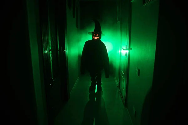 ハロウィンのコンセプトです カボチャの頭を持つ暗い廊下で不気味なシルエット 背景に霧と光のトーン — ストック写真