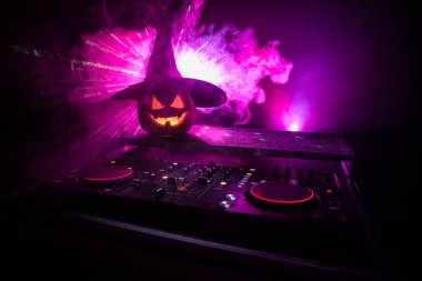 Cadılar Bayramı Balkabağı kopya alanı ile koyu arka plan üzerinde kulaklık ile bir dj tablo. Mutlu Cadılar Bayramı festival süsleri ve müzik konsepti. Boş alanı. Seçici odak