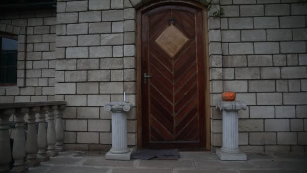 家の玄関は ハロウィンのカボチャで飾られました 夜急なドアにハロウィンかぼちゃ — ストック動画