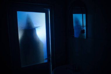 Korku penceresinde kadın silüeti. Korkunç Cadılar Bayramı kavramı bulanık silueti banyoda cadı