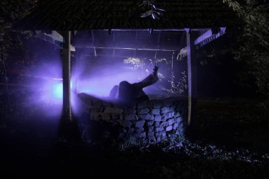 Uzun siyah saçları korkunç bir kızla kasvetli bir kuyuda duruyor. Korkunç Cadılar Bayramı fotoğraf. Ölü zombi kız kuyudan tırmanıyor