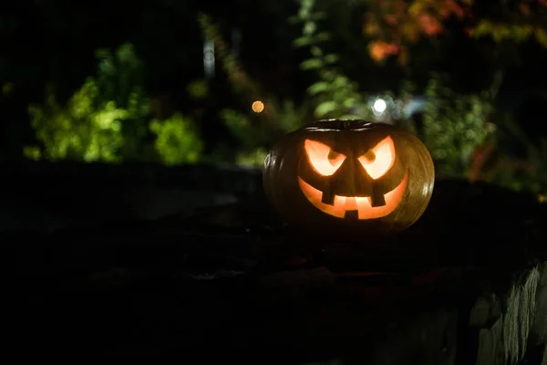Halloween pumpkin. Carved Halloween pumpkin glowing in the dark. Outdoor shot