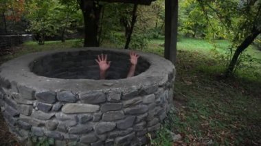 Uzun siyah saçları korkunç bir kızla kasvetli bir kuyuda duruyor. Korkunç Cadılar Bayramı fotoğraf. Ölü zombi kız kuyudan tırmanıyor