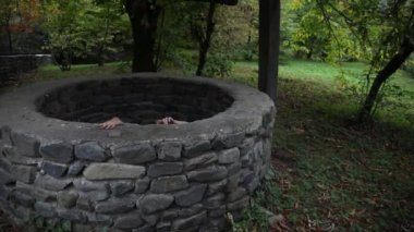 Uzun siyah saçları korkunç bir kızla kasvetli bir kuyuda duruyor. Korkunç Cadılar Bayramı fotoğraf. Ölü zombi kız kuyudan tırmanıyor