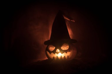 Cadılar Bayramı kavramı. Jack-o-lantern gülümseme ve gece parti için korkutucu gözler. Korkutucu Kabak cadı Karanlık sisli arka plan, şapkası ile görünümünü kapatın. Seçici odak. Boş alan