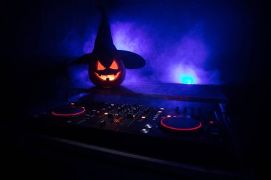 Cadılar Bayramı Balkabağı kopya alanı ile koyu arka plan üzerinde kulaklık ile bir dj tablo. Mutlu Cadılar Bayramı festival süsleri ve müzik konsepti. Boş alanı. Seçici odak