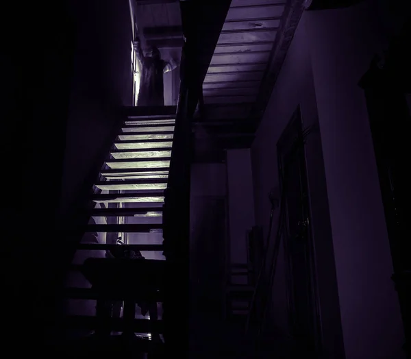 在旧的令人毛骨悚然的废弃豪宅内 恐怖幽灵剪影站在城堡楼梯到地下室 鬼地牢石楼梯在老城堡与光 恐怖万圣节概念 — 图库照片