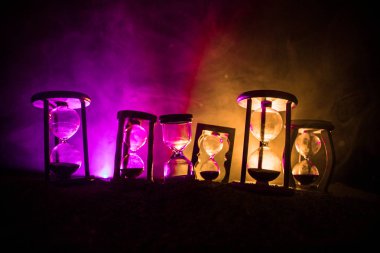 Zaman kavramı. Hourglasses siluetleri karanlık arka aydınlatma ile sisli arka plan tonda. Soyut gerçeküstü kavramı kopya alanı ile. Seçici odak