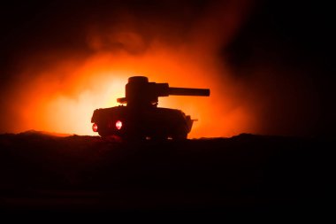 Savaş kavramı. Zırhlı Tank siluet aşağıda sisli yangın gökyüzü gece. Saldırı sahne. Oyuncak dekorasyon. Seçici odak