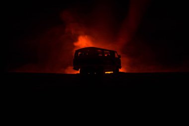 Koyu tonda sisli gökyüzü arka plan üzerinde roader jeep siluet. Araba ile gece ışık. Seçici odak