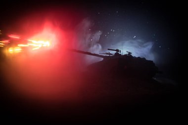 Savaş kavramı. Zırhlı Tank siluet aşağıda sisli yangın gökyüzü gece. Saldırı sahne. Oyuncak dekorasyon. Seçici odak
