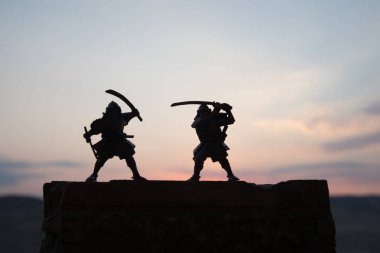 Düelloda iki samurais silüeti. İki samurais ve günbatımı gökyüzü ile hayal et. Seçici odak