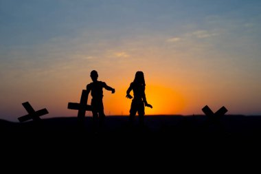 Bazı zombiler üzerinde günbatımında dolaşan mezarlığı siluet. Seçici odak