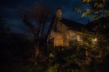 Binanın Orman geceleri ay veya vintage kır evi ile bulutlar ve yıldız ile gece dağ gece manzarası. Yaz gecesi. Uzun pozlama ile çekilen fotoğraf
