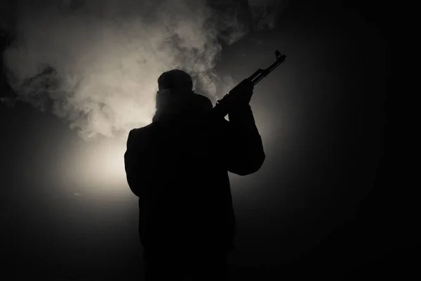 有突击步枪的人的剪影准备攻击黑暗的色调雾蒙蒙的背景或拿着枪的危险强盗 射击恐怖分子与武器主题装饰 — 图库照片