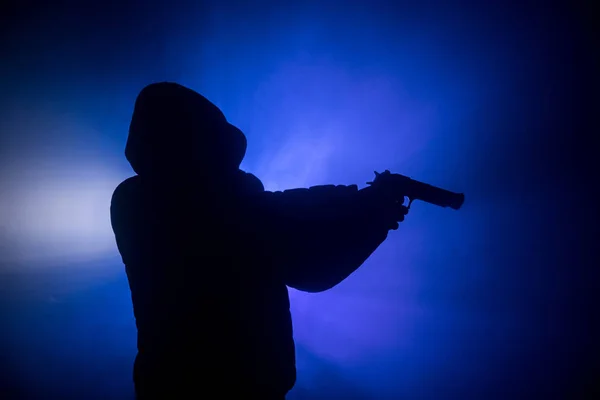 ダークで攻撃する準備ができてのピストルを持った男のシルエット トーン霧の背景や危険な山賊持株銃手 武器のテーマの装飾が施されたテロリストを撮影 — ストック写真