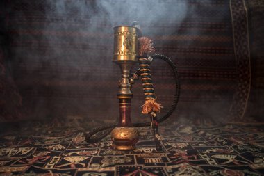 Nargile kömürü nargile kupa Arap iç de buhar bulutları yapma. Şark süsleme halı üzerinde. Şık oryantal shisha aydınlatmalı. Shisha reklam için. Seçici odak