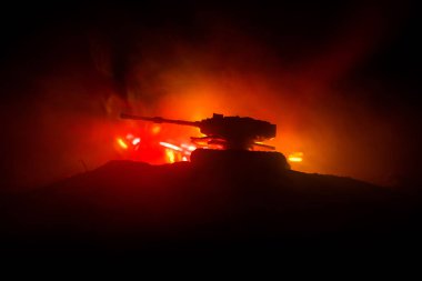 Savaş kavramı. Zırhlı Tank siluet aşağıda sisli yangın gökyüzü gece. Saldırı sahne. Oyuncak dekorasyon. Seçici odak